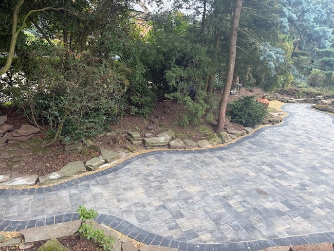 Finished sandstone patio surrounded by garden landscaping